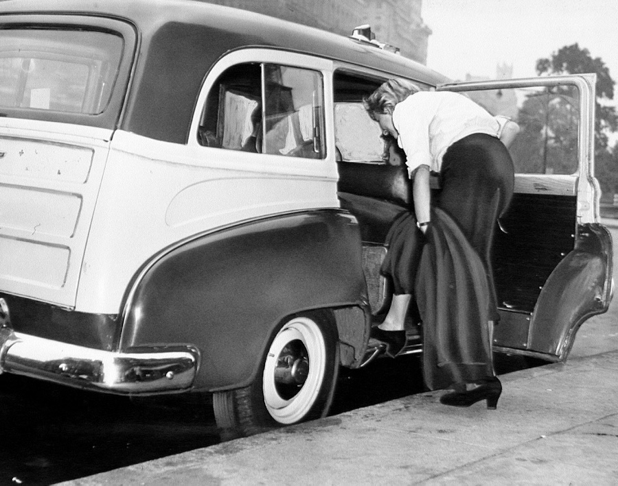 A fair fare enters one of Manhattan's new cabs at Columbus Circle in Manhattan. Converted station wagons, two feet shorter than the previous vehicles.