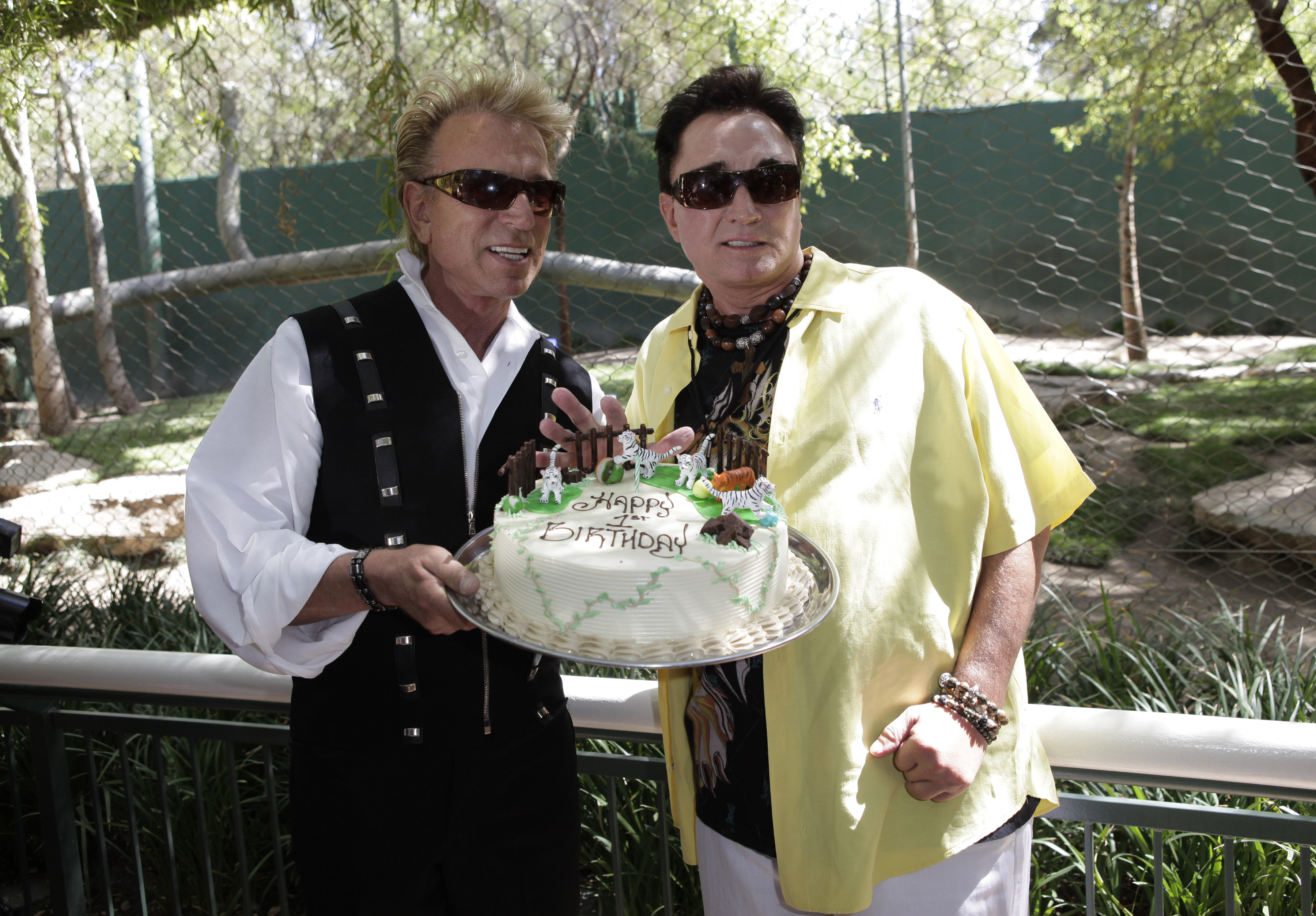 Siegfried Fischbacher, left, and Roy Horn shows a cake as they celebrate tiger cubs' first birthday at Secret Garden & Dolphin Habitat at the Mirage hotel and casino in Las Vegas, on May 12, 2009.